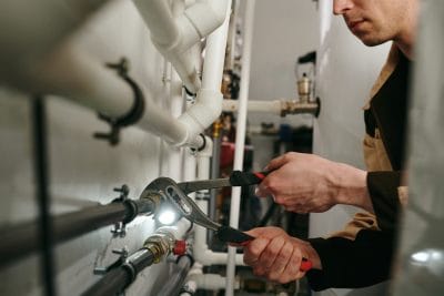 Technician inspecting commercial plumbing pipes in Petaluma